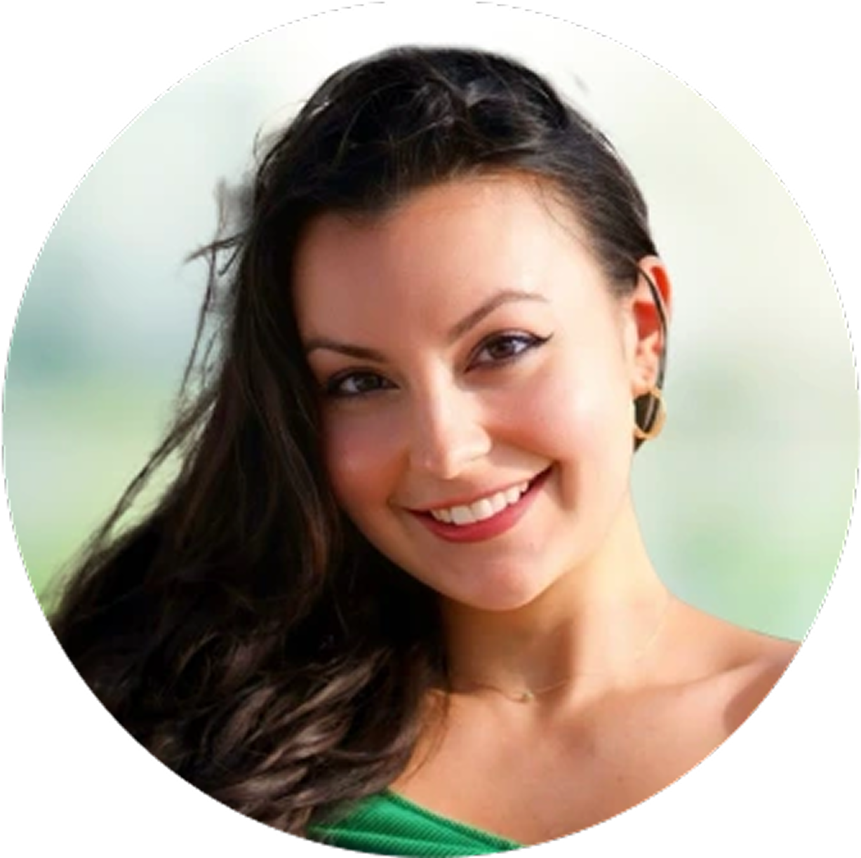 Smiling woman with long black hair and gold hoop earrings wearing green top