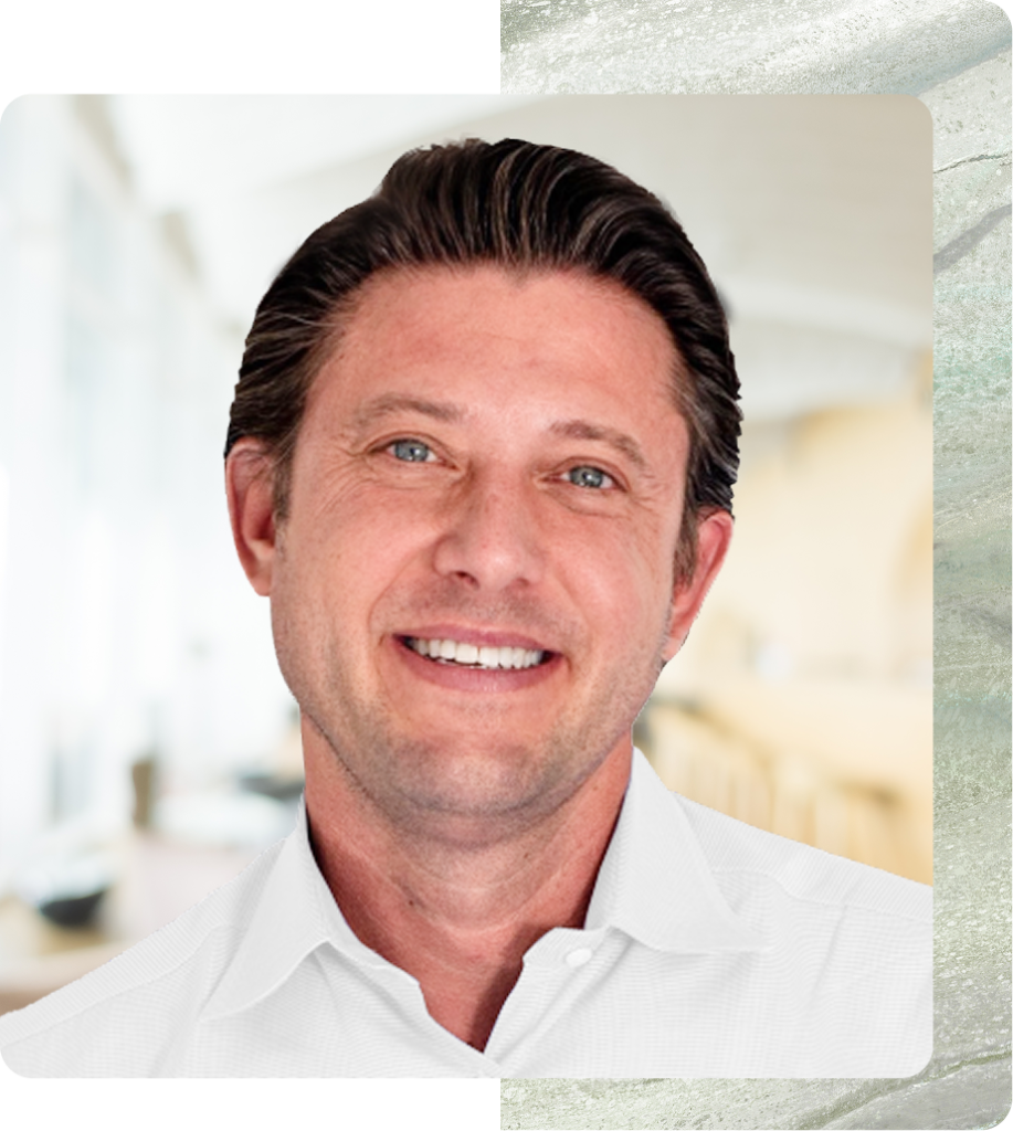 Man with dark hair and blue eyes wearing white button-up shirt in medical office setting