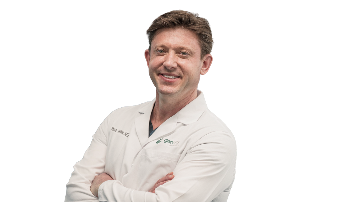 Male physician in white coat smiling with arms crossed