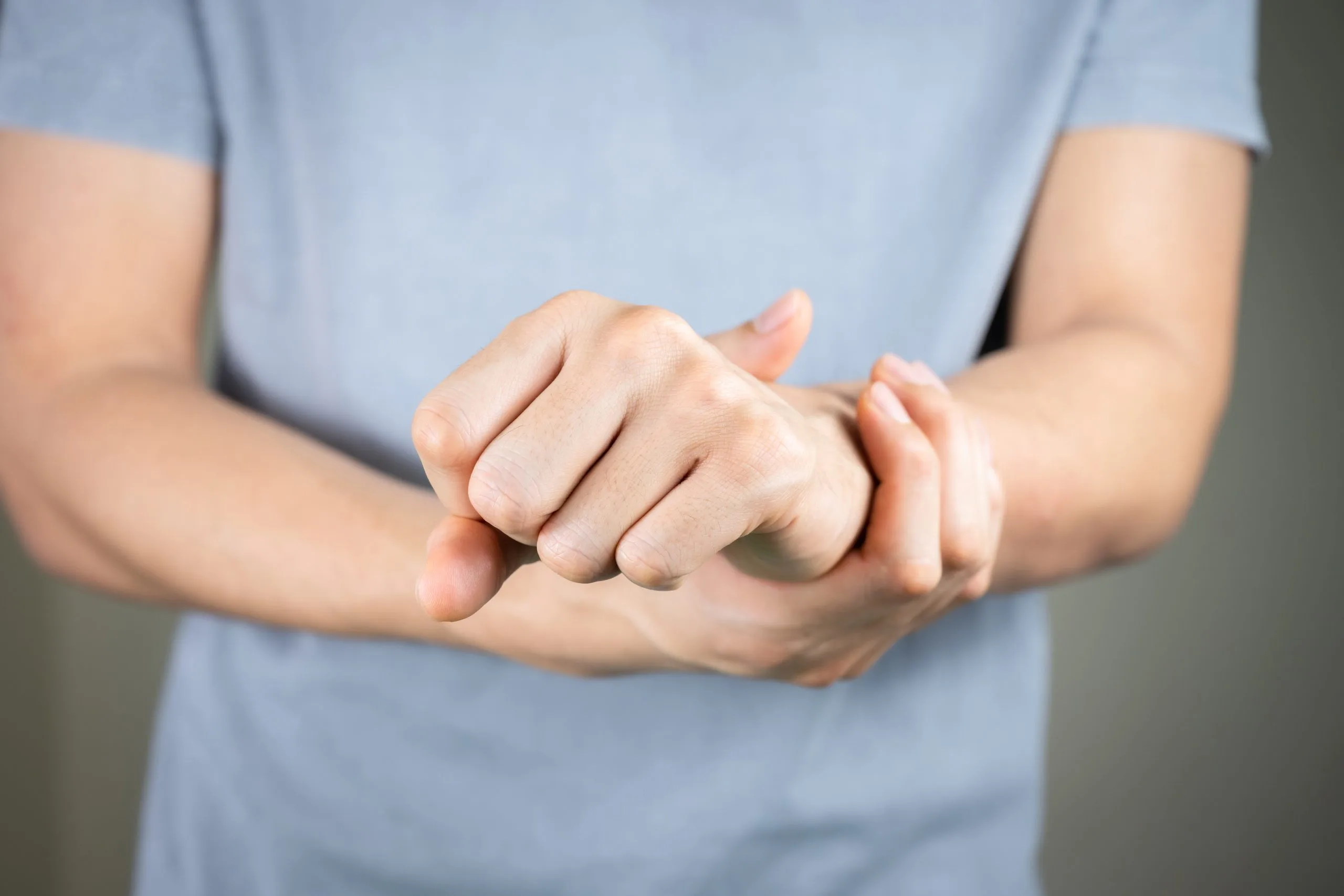 Person examining their forearm and wrist with their other hand
