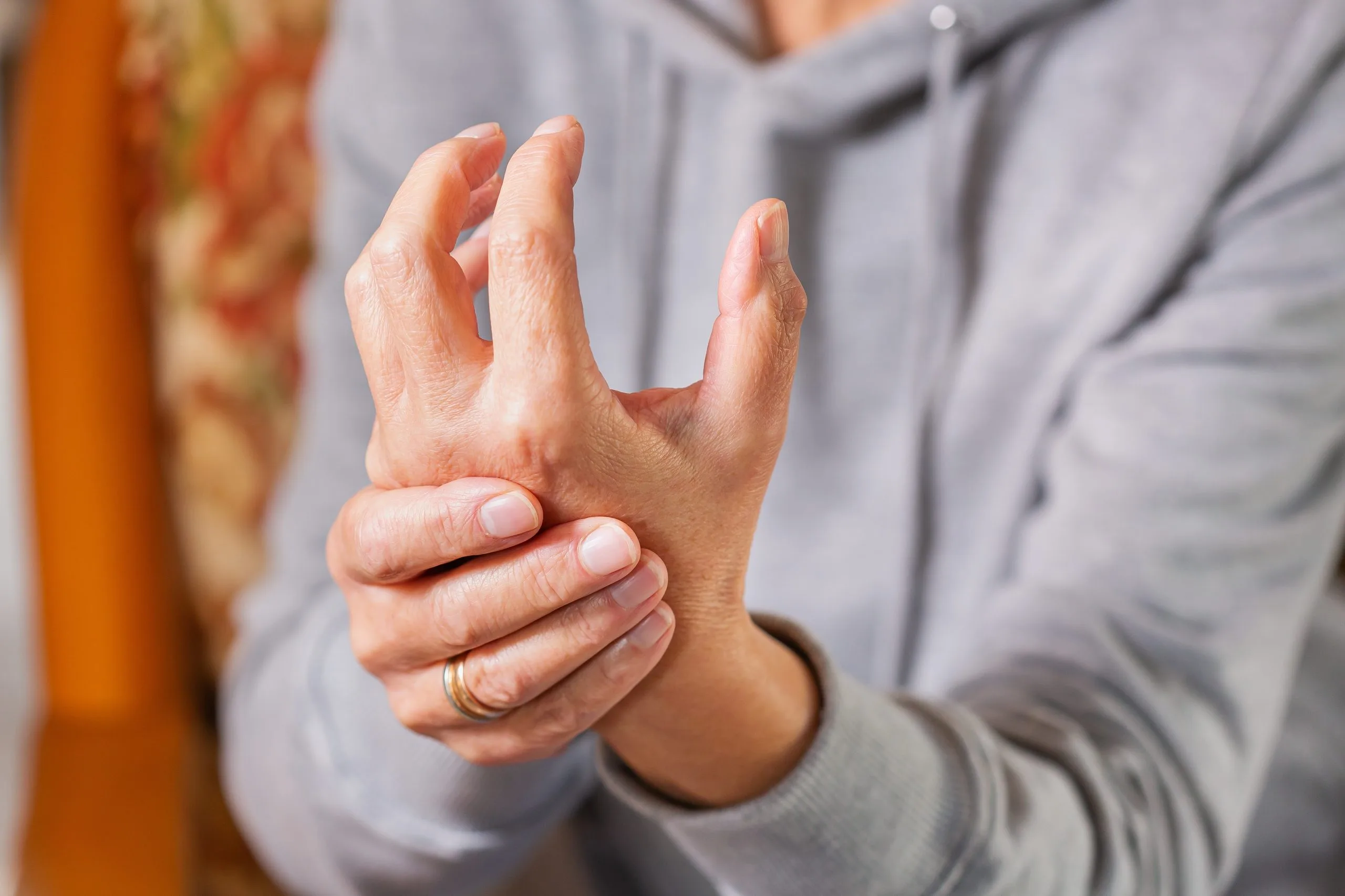 Person holding their hand with visible strain or discomfort