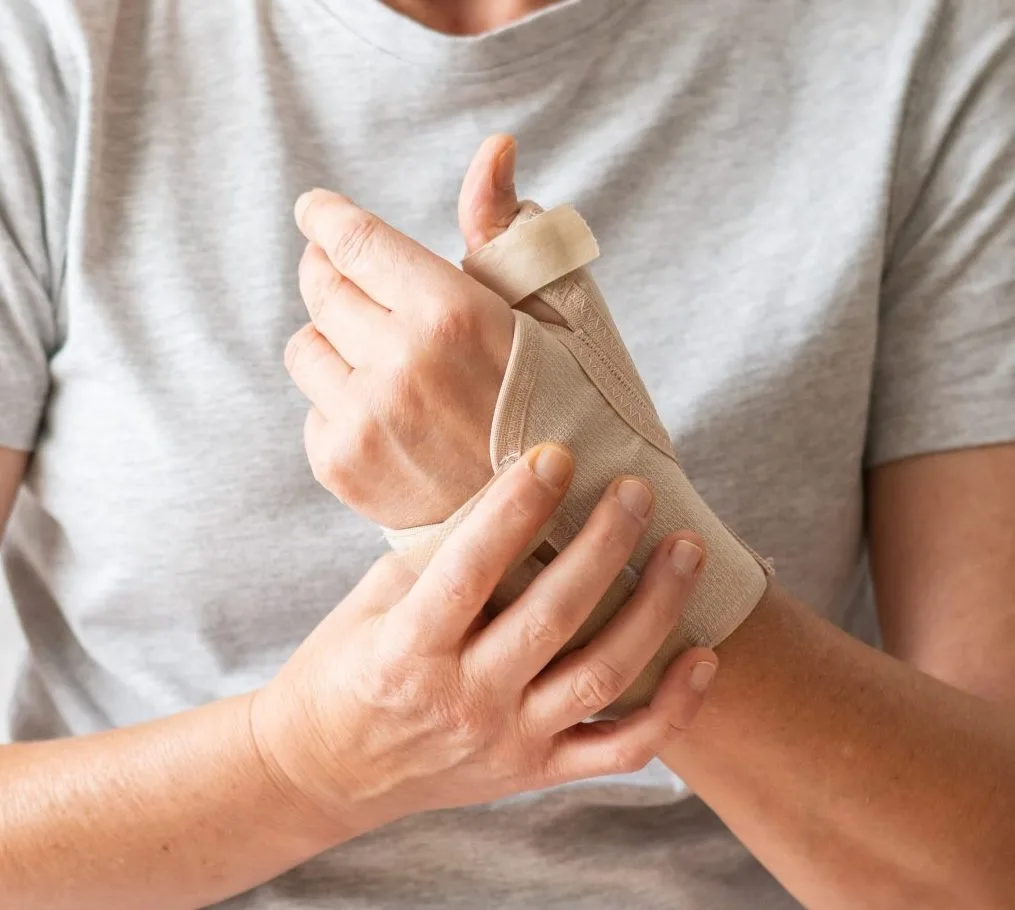 Person wearing a beige wrist brace on their hand and forearm