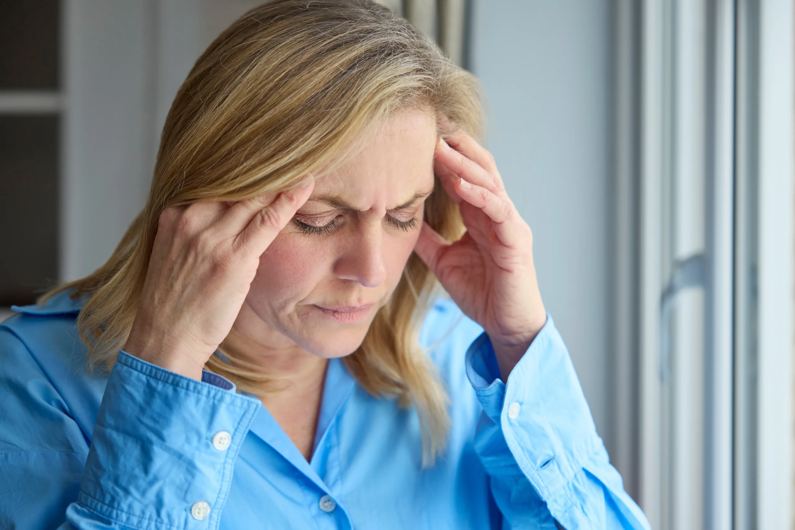Woman pressing her temples during a migraine