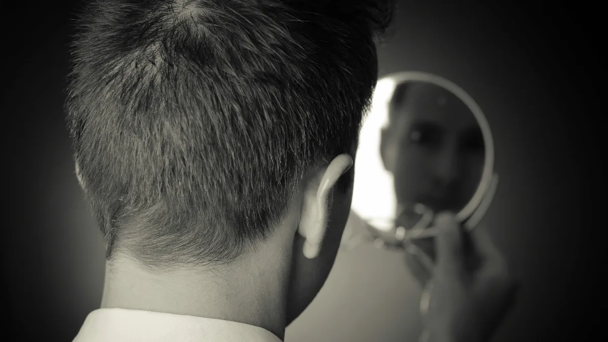 Man checking the back of his head where occipital pain starts