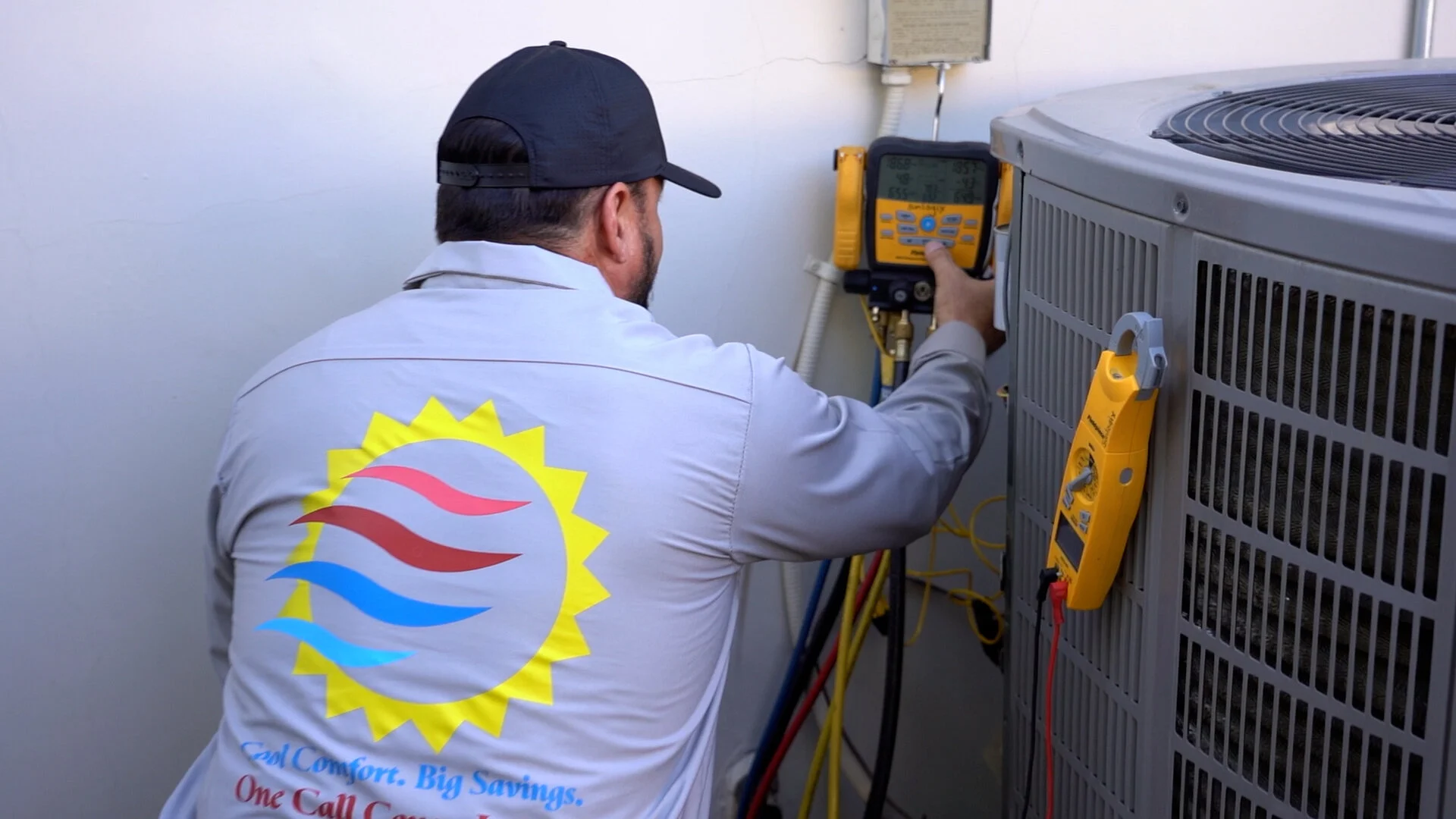 Sunlogix HVAC technician checking refrigerant pressures on an outdoor unit in Palm Desert