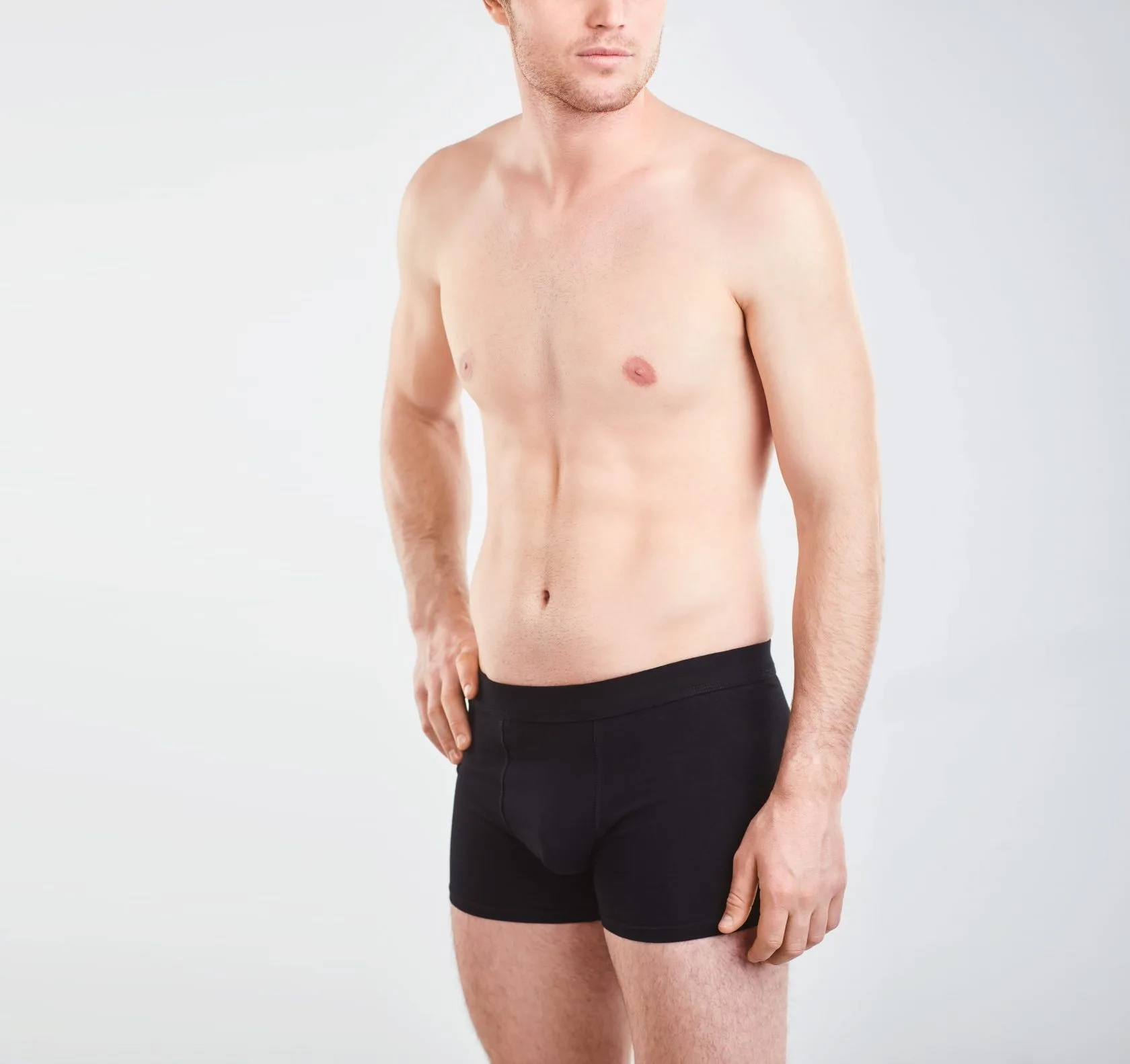 Man in black underwear against a gray background