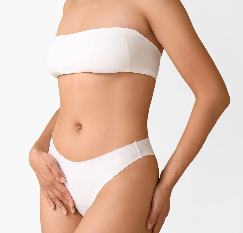 Woman with toned abdomen wearing white bandeau top and briefs