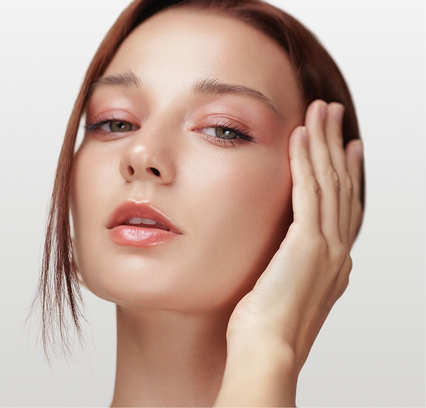 Woman with defined jawline touching her face, demonstrating facial contours