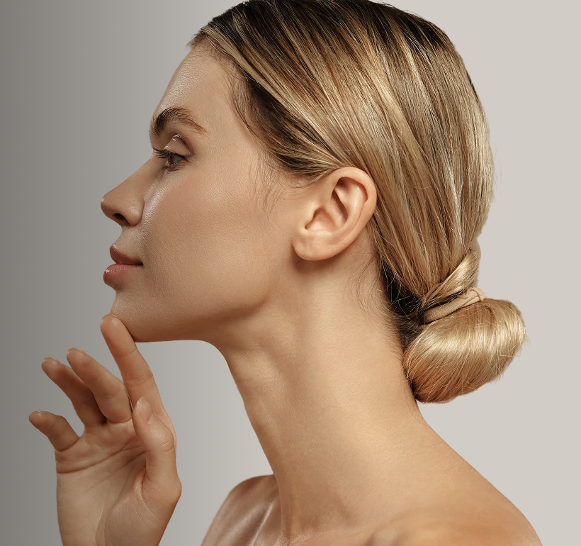 Woman in profile touching her jawline, demonstrating facial contour