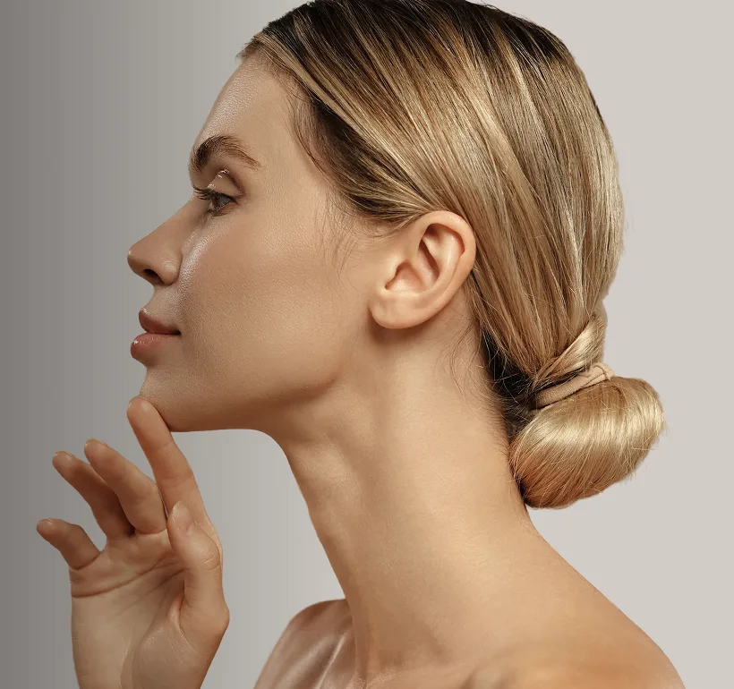 Woman in profile touching her jawline, demonstrating facial contour