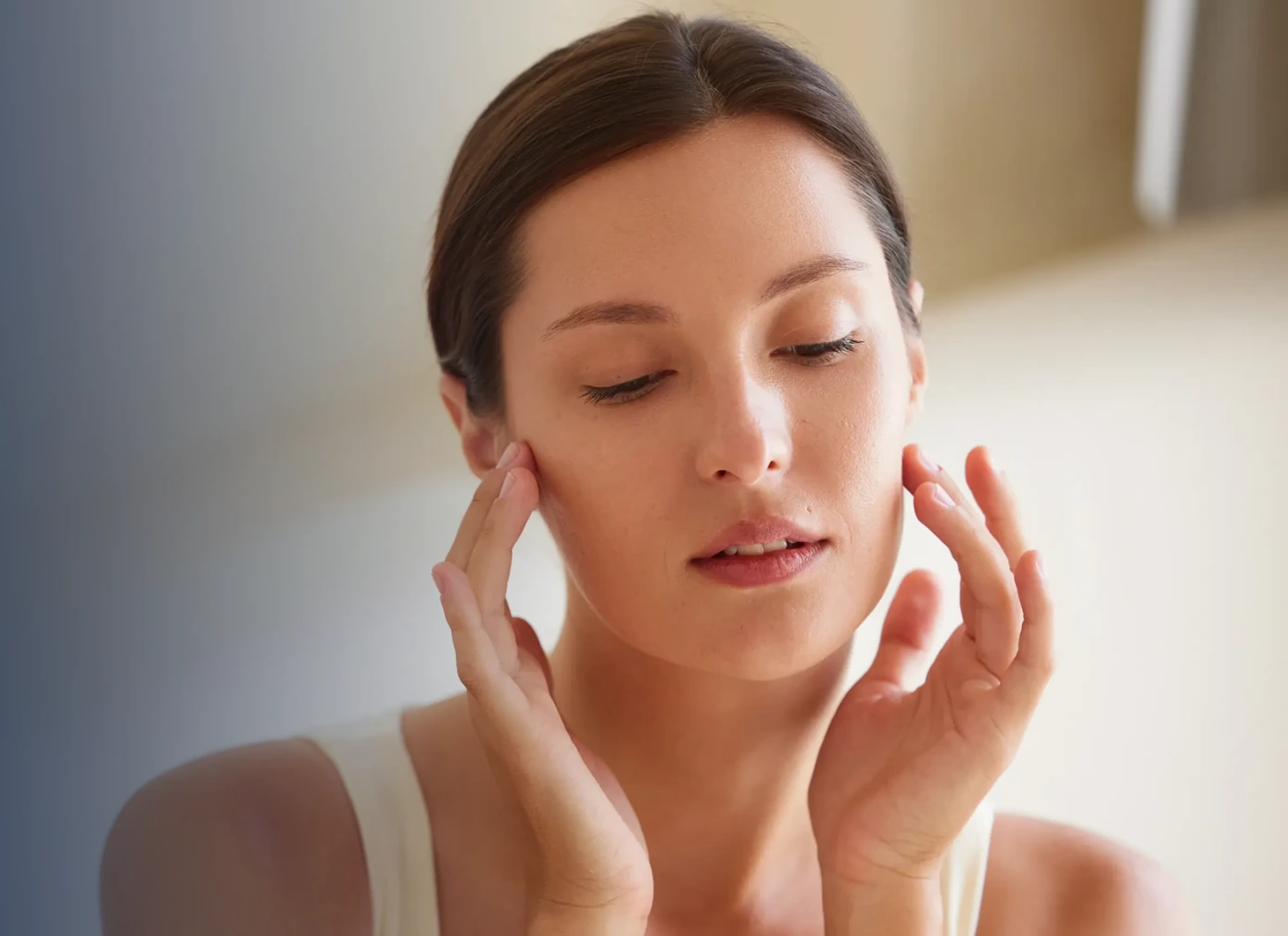 Woman applying skincare product to her face with both hands