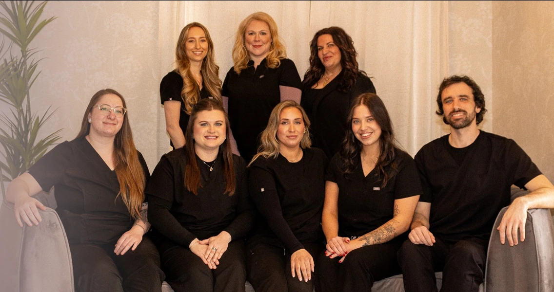 Thrive Spa team of nine staff members in black uniforms posing together indoors