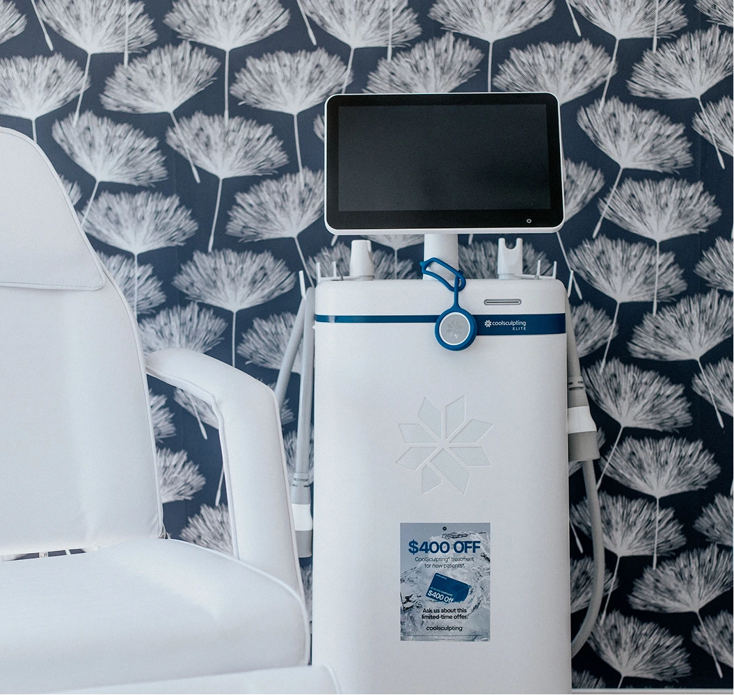 CoolSculpting Elite device with touchscreen display and blue applicator handle against dandelion-patterned wall