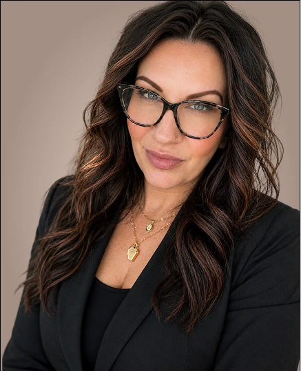 Dr. Brandy portrait wearing glasses and black blazer with gold necklace