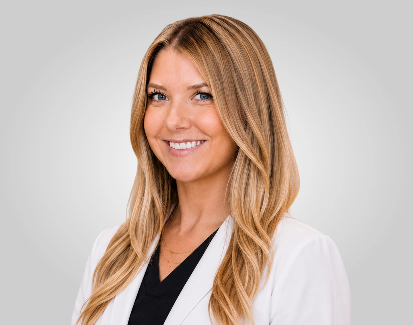 Dr. Sarah portrait with long blonde hair wearing white coat and dark top