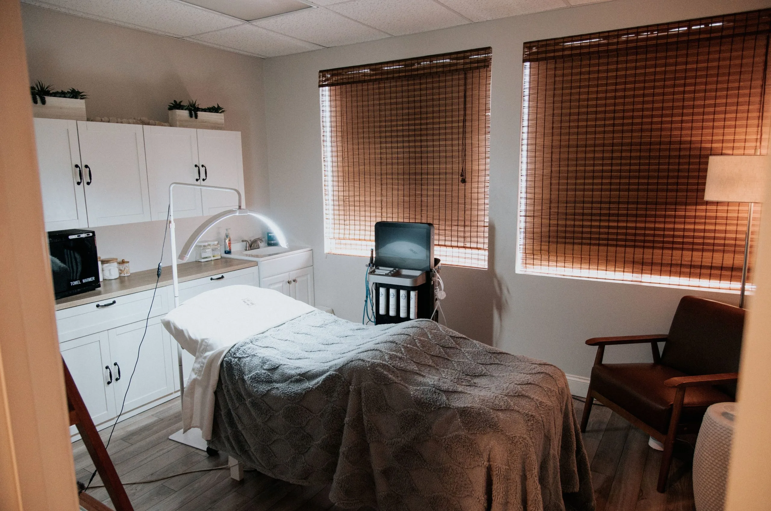 Prenatal massage treatment room at Thrive Med Spa with massage table, white cabinetry, and warm lighting