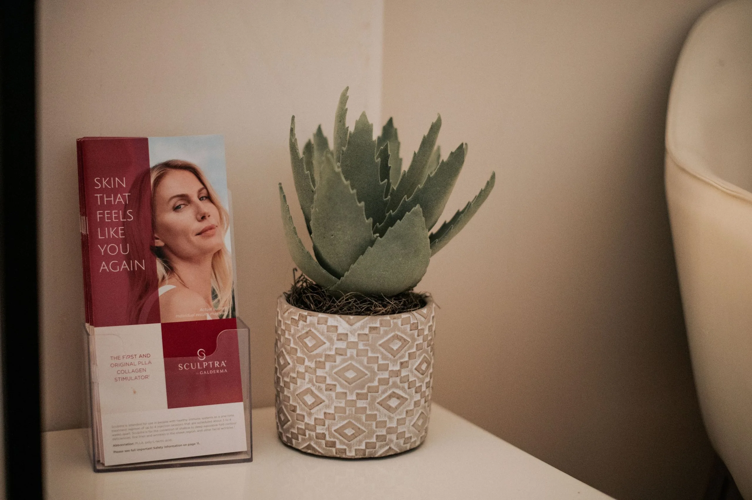Sculptra Galderma collagen stimulator product box beside a potted succulent in a spa treatment room