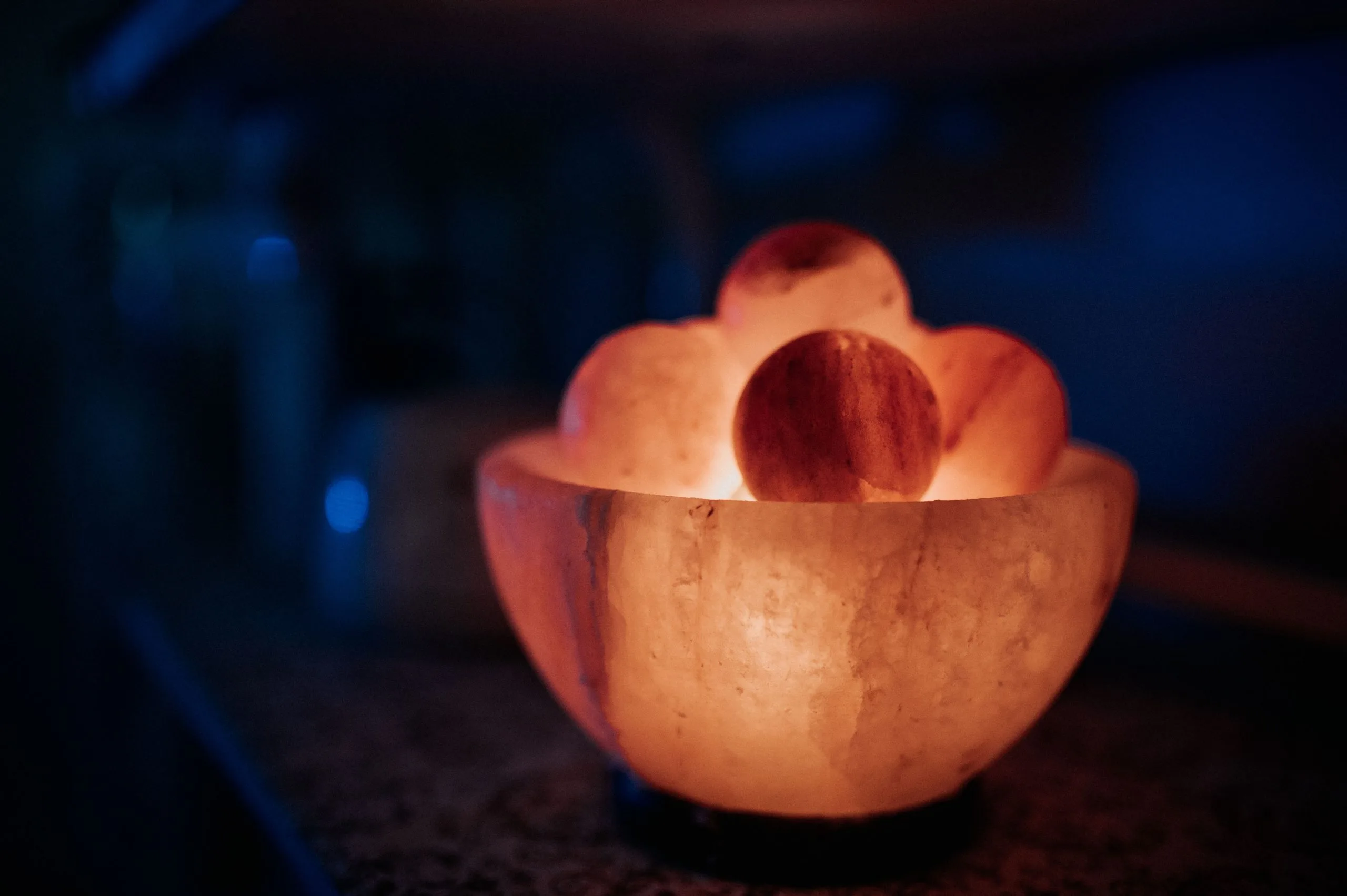 Lit Himalayan salt bowl with glowing spheres inside, creating warm ambient light
