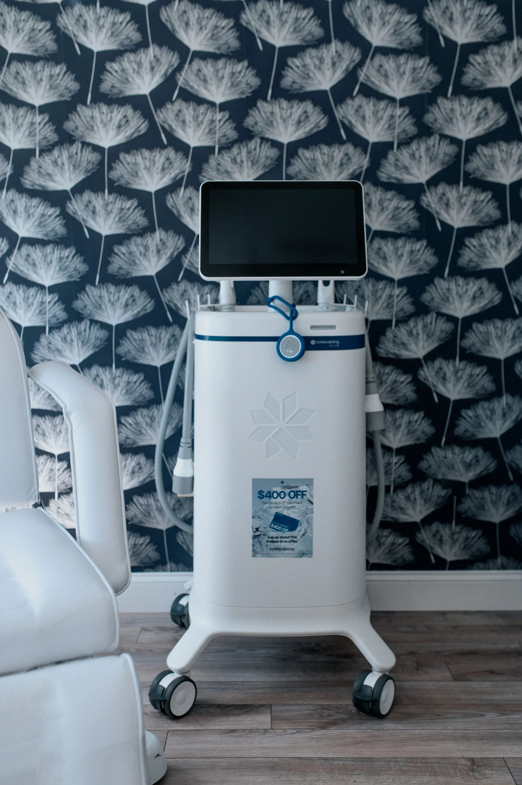 CoolSculpting device with touchscreen display and applicator in Thrive Med Spa treatment room, $400 OFF promotional badge visible
