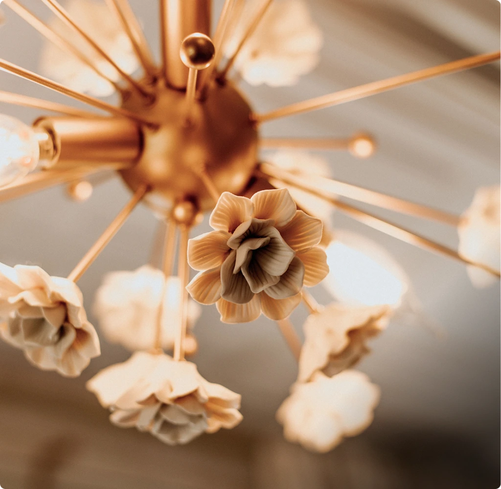 Close-up of dried flowers on a gold stem against a soft neutral background