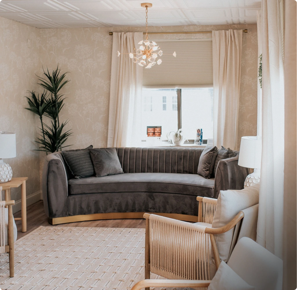 Thrive Med Spa & Wellness Portsmouth waiting room with gray sofa, wooden chairs, pendant light, and plants