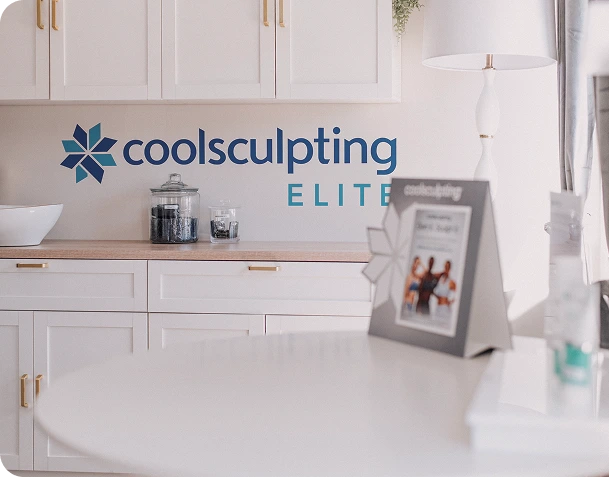 CoolSculpting Elite logo and signage in a bright med spa treatment room with white cabinetry