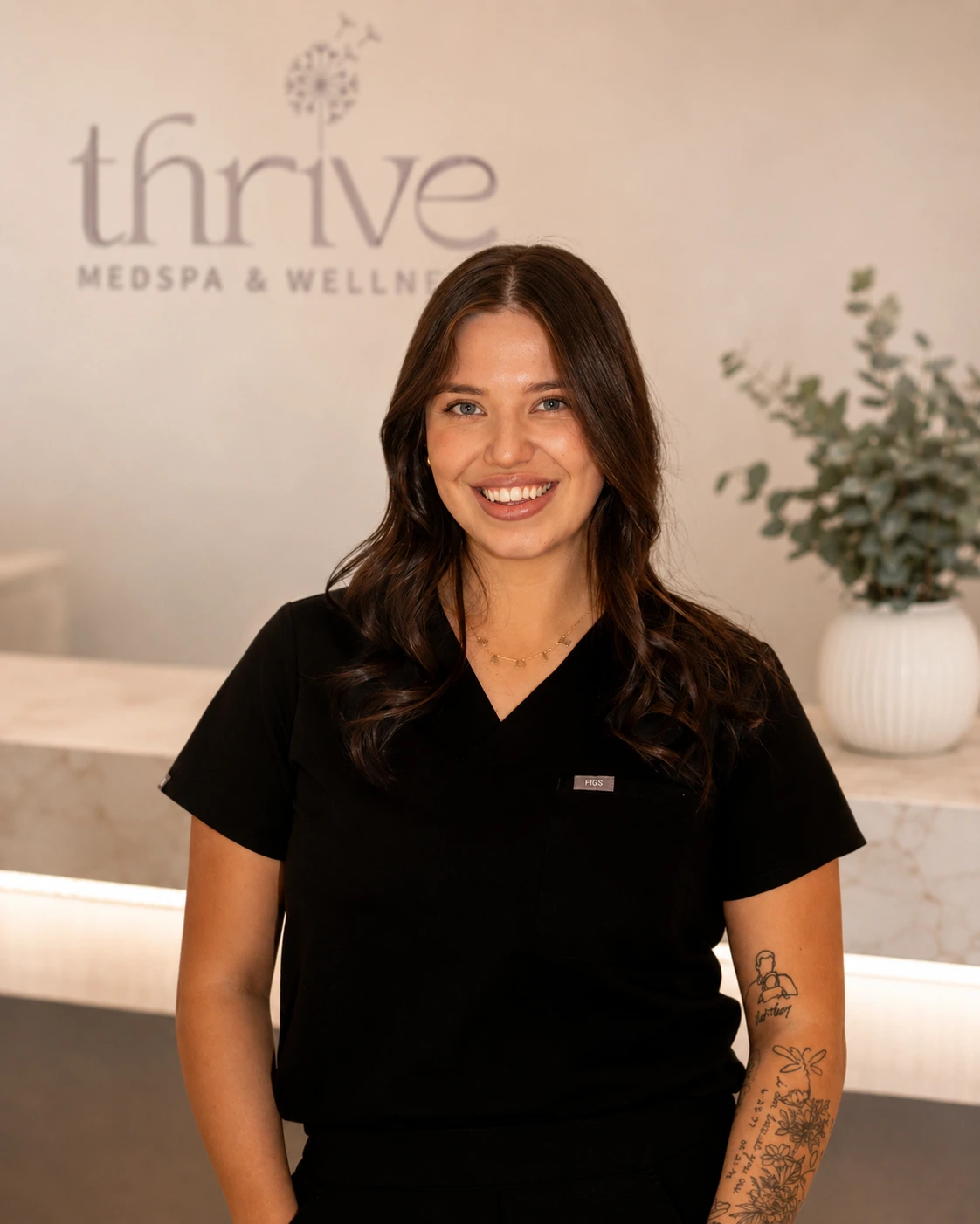 Team member smiling at Thrive Med Spa + Wellness reception area