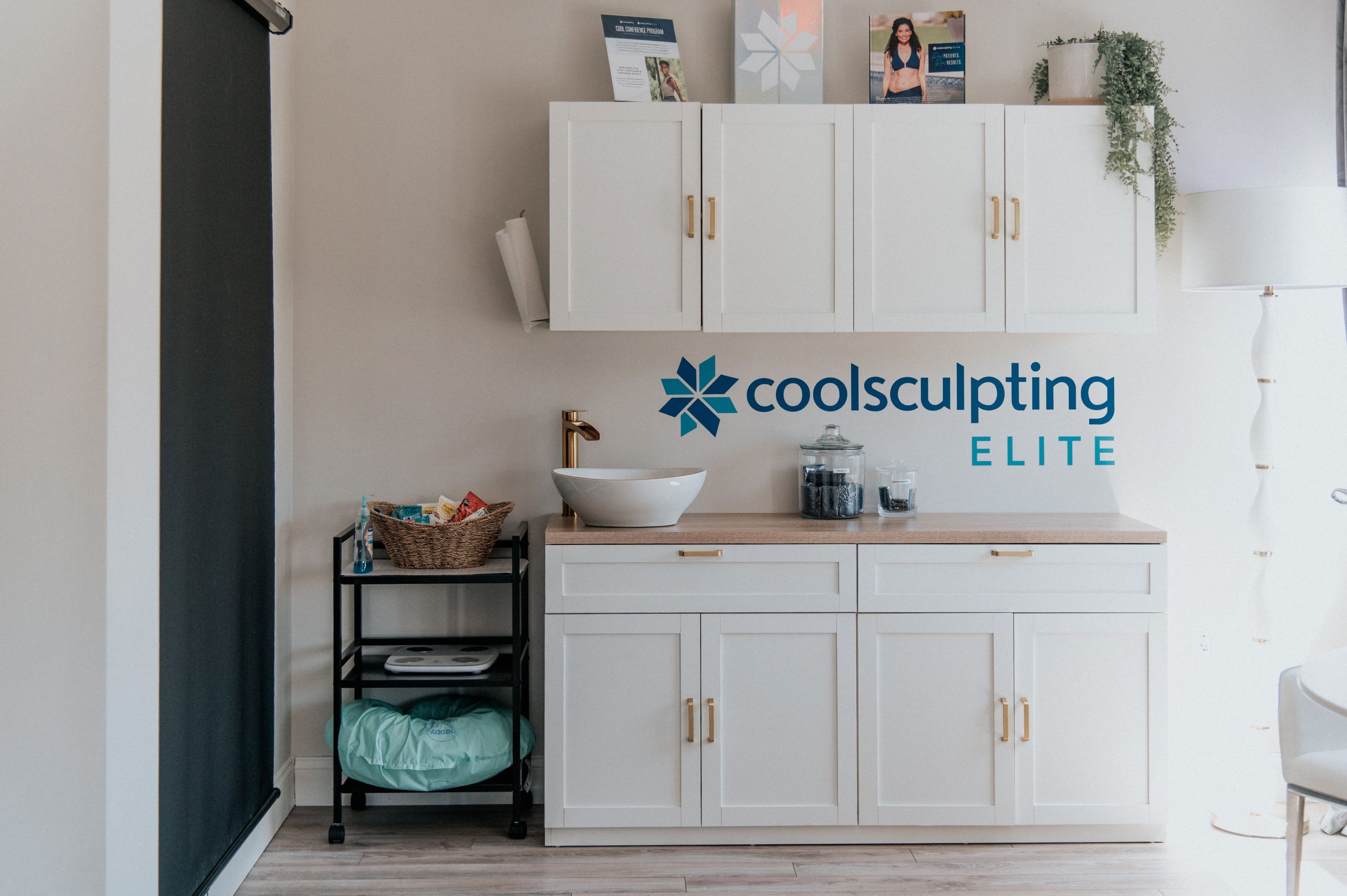 Modern bathroom vanity with CoolSculpting Elite logo and signage displayed on wall