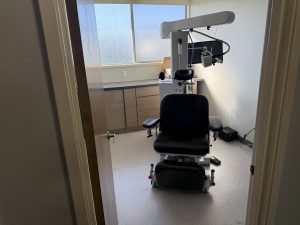 TMS therapy treatment room with patient chair, overhead coil device, and window view at Rancho Mirage location