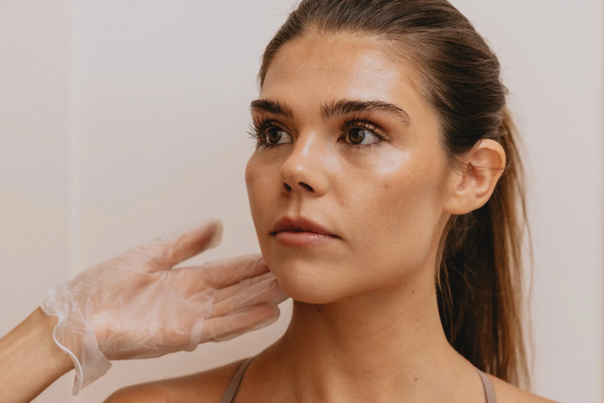 Provider assessing a patient jawline before CoolSculpting at TREAT Medspa in NYC