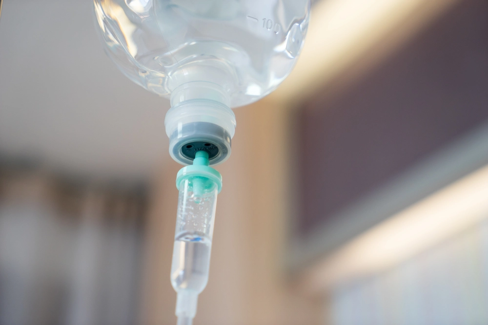 IV drip bag connected to tubing with turquoise connector
