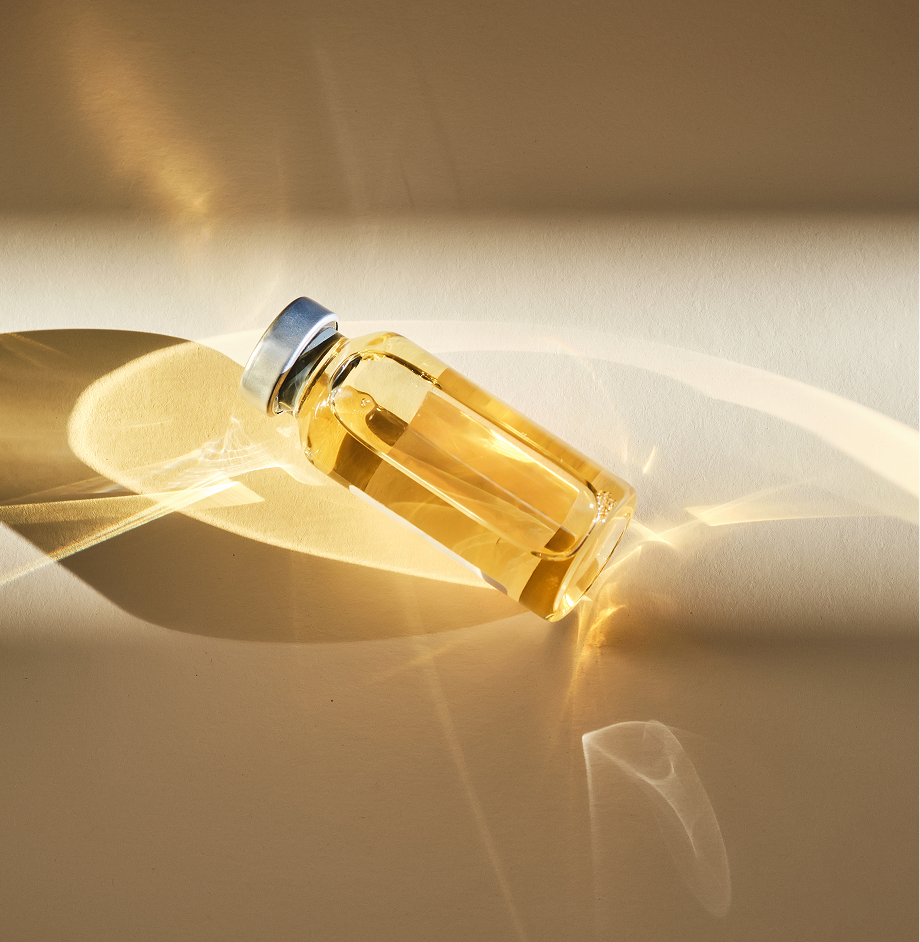 B12 supplement vial with yellow liquid and metal cap on white surface in sunlight