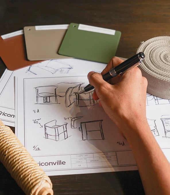 Designer sketching a chair beside material swatches
