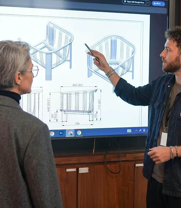 Designers reviewing a chair drawing on screen