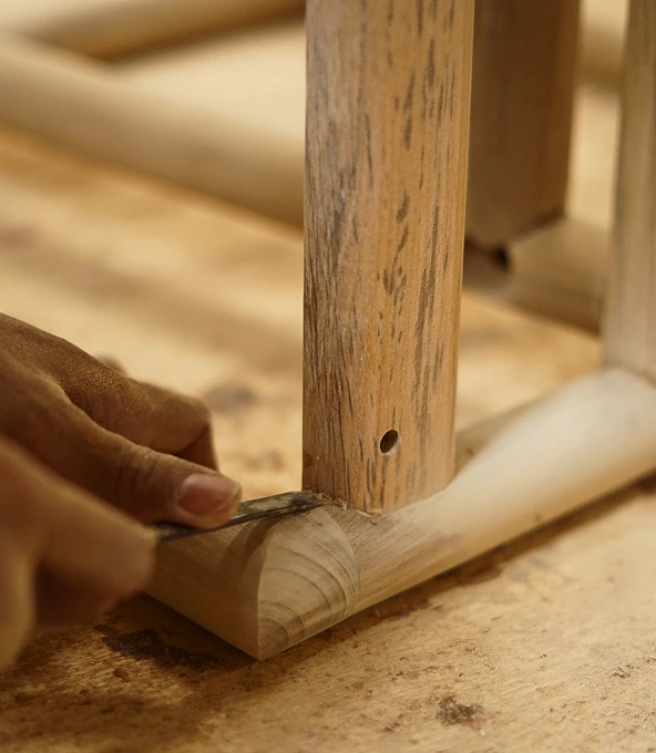 Craftsman shaping a teak joint