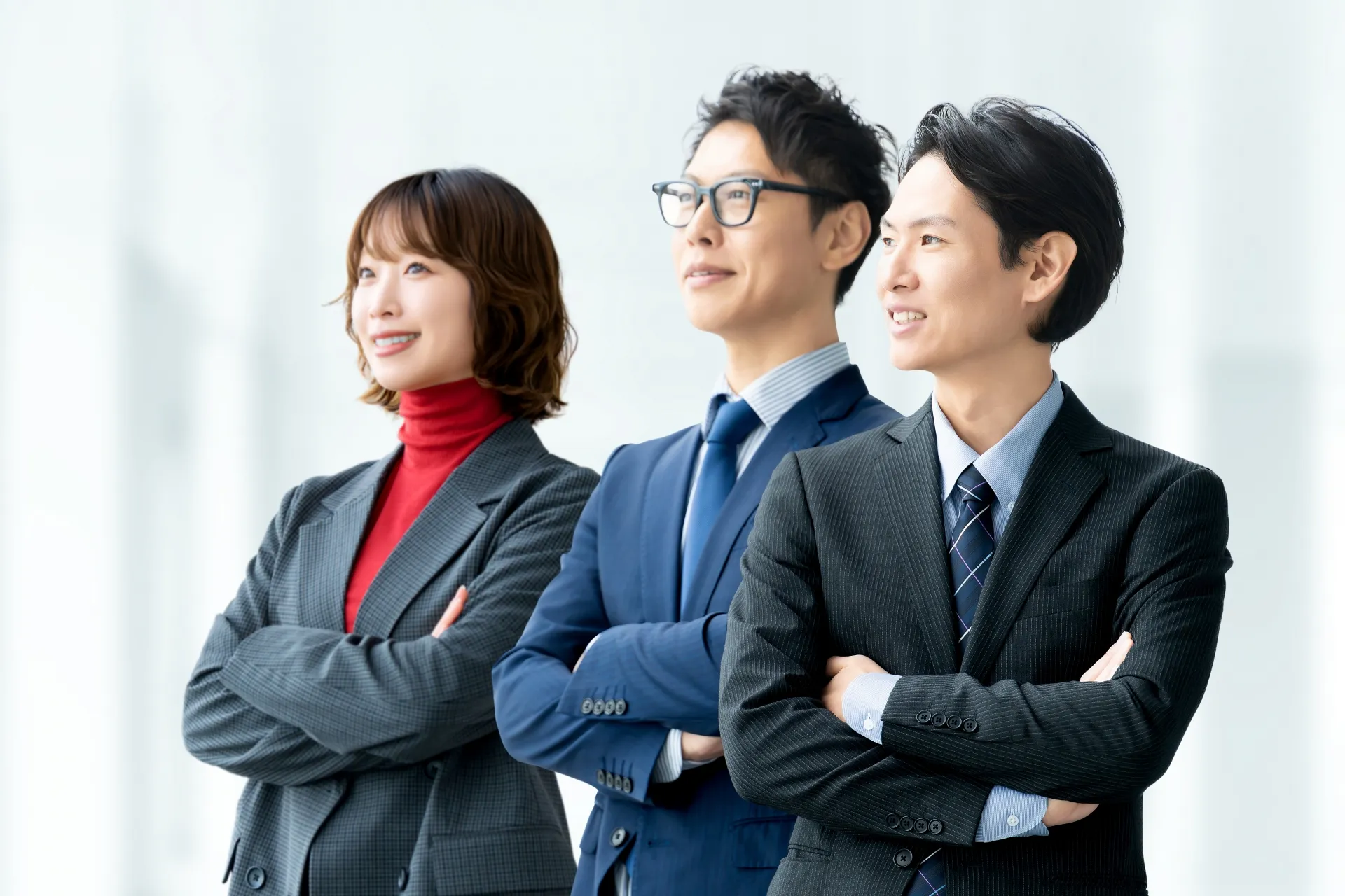 Three people in suits with arms crossed