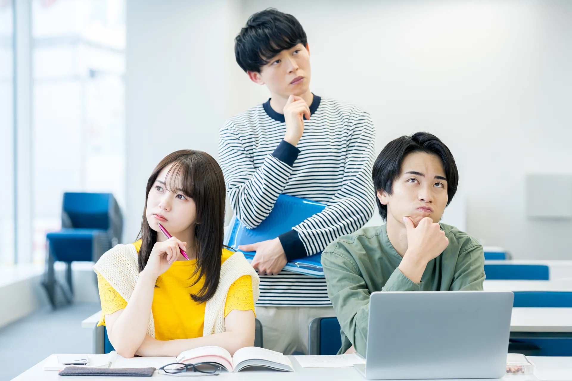 室内で悩む3人の若者