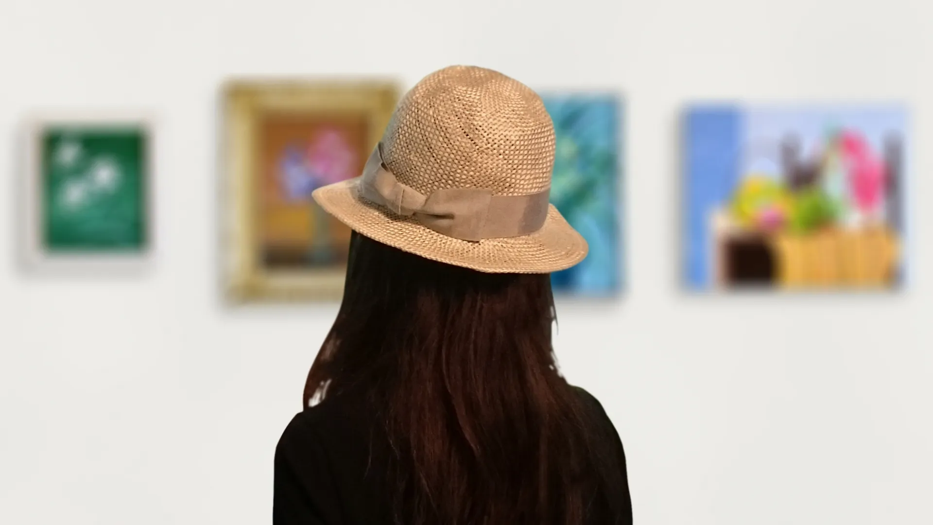 美術館で絵を見る女性の後ろ姿