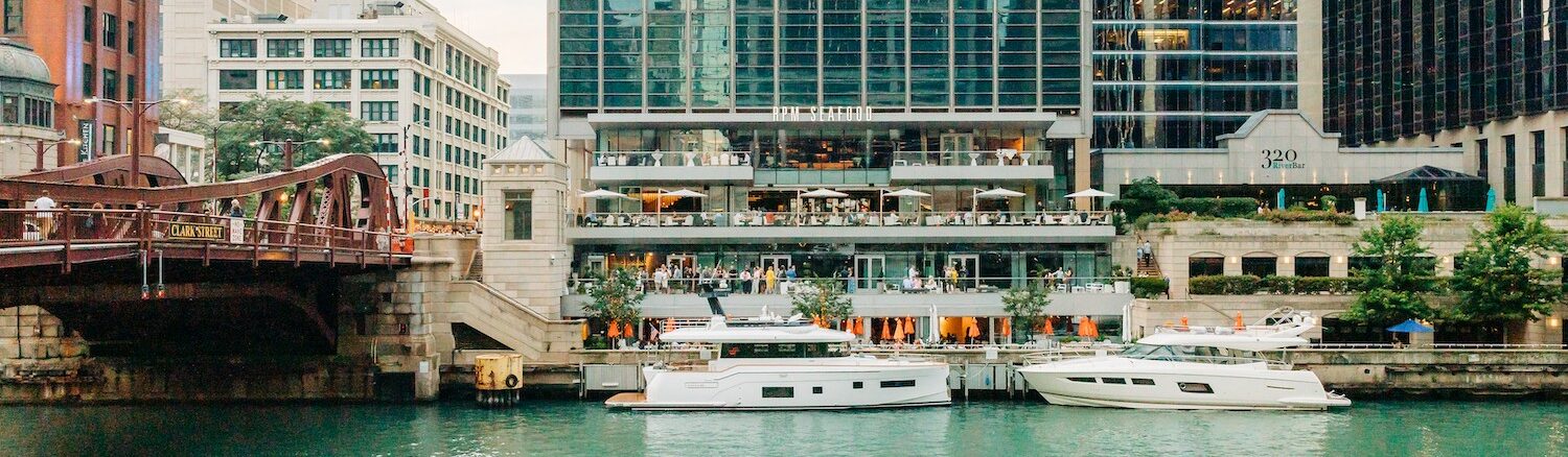 Riverfront view of Pizzeria Portofino and RPM seafood with two yachts docked in front