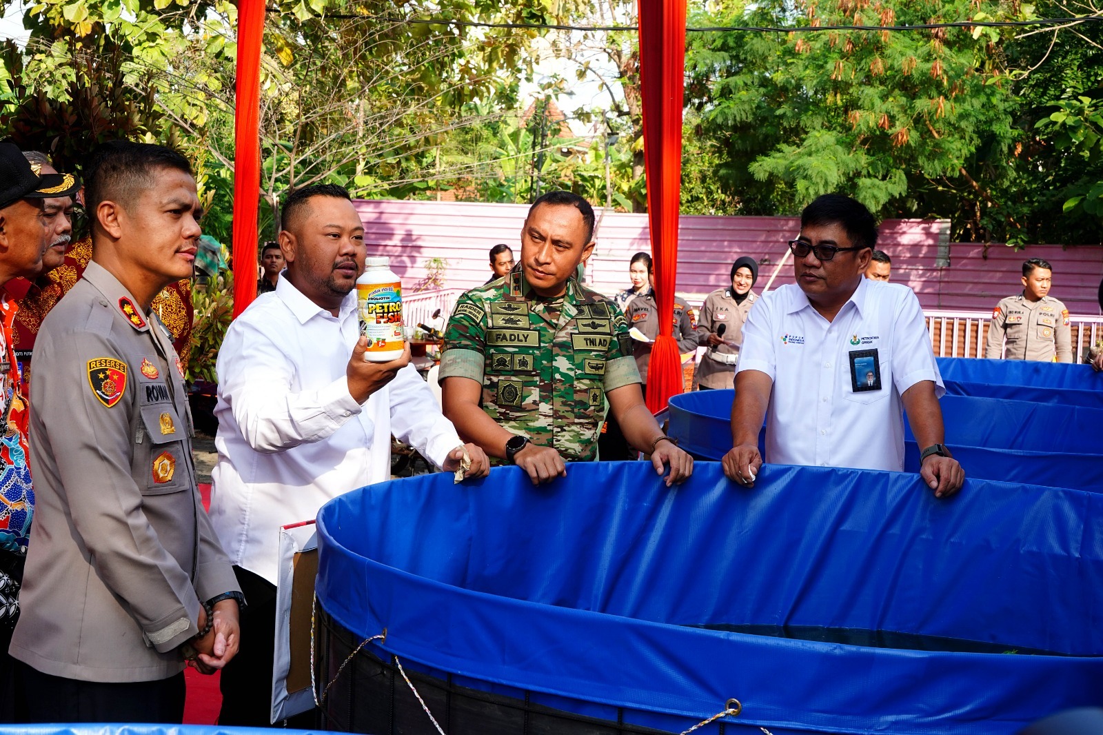Bupati Gresik, Fandi Akhmad Yani (baju putih) didampingi jajaran Polres, Kodim 0817, dan Direktur Utama Petrokimia Gresik, Daconi Khotob (paling kanan) mengenalkan produk probiotik Petrofish pada Launching
foto : Corcomm PG