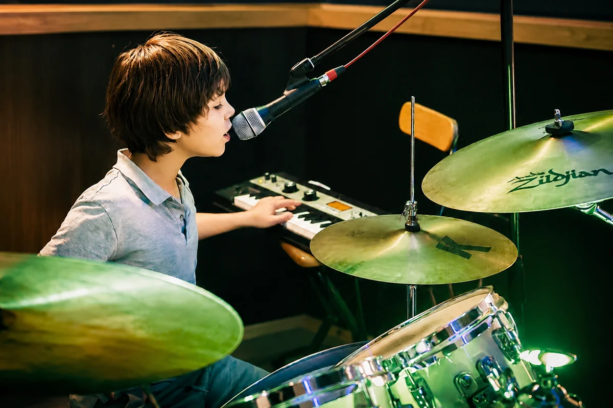 A child playing drums and singing during a lesson