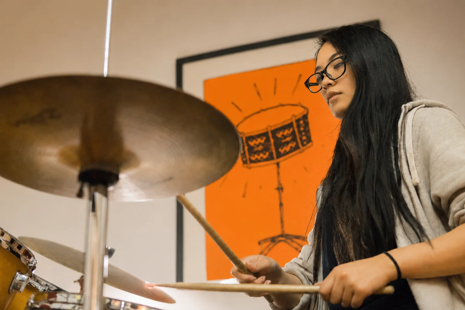 A student playing drums during a lesson at Planet drum