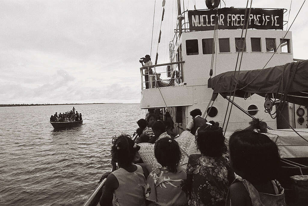 Rongelap Islanders crowded into a small boat approach the Rainbow Warrior.