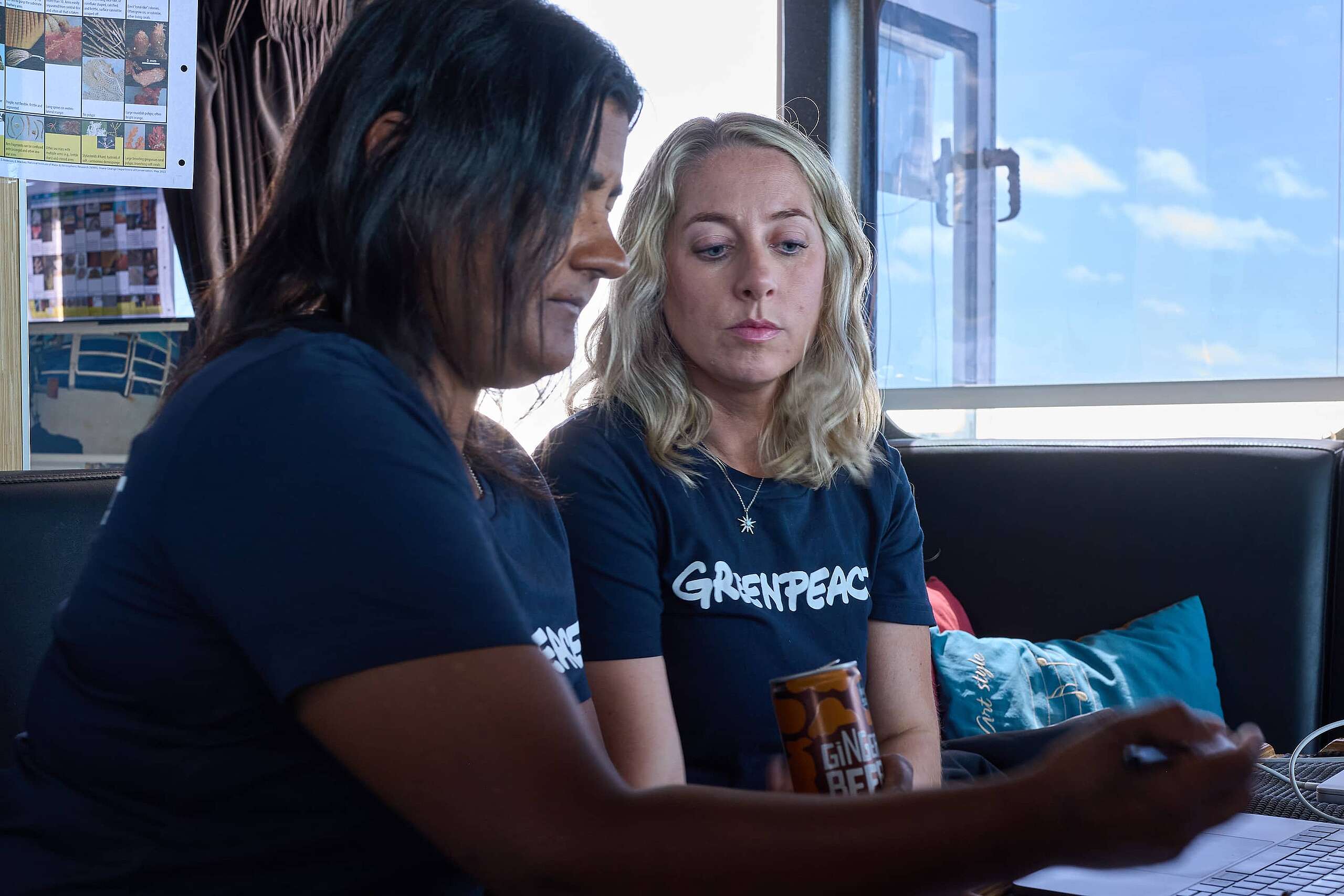 Lead scientist Kat sits with oceans campaigner Ellie, as they look at images from deep sea cameras on a laptop