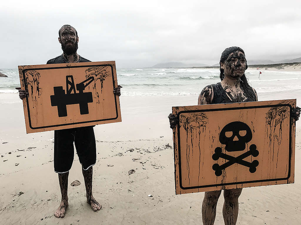 Voluntários do Greenpeace seguram placas com imagem de uma plataforma de petróleo e da morte para protestar contra exploração de petróleo perto dos Corais da Amazônia.