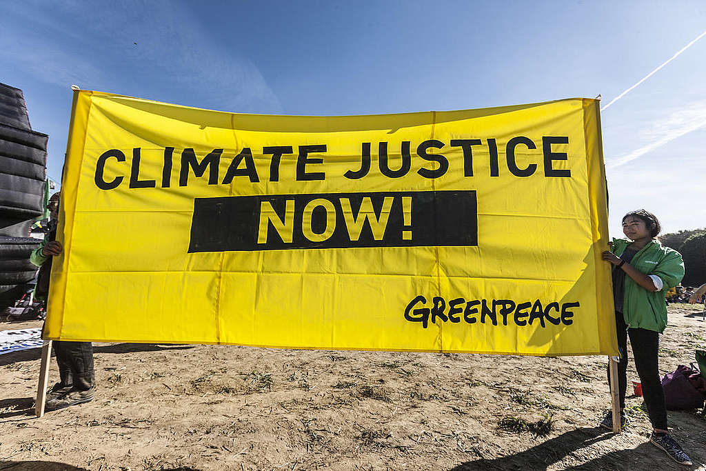 Manifestantes seguram placa que diz: 'Justiça para o clima agora!'