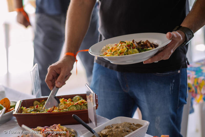 homem segura um prato de comida vegano. 