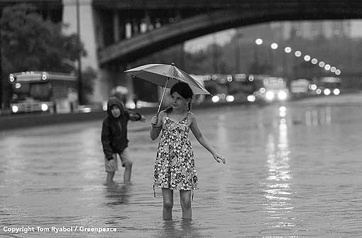 Girl walks through water on the flooded DVP during the July 2013 flash flood