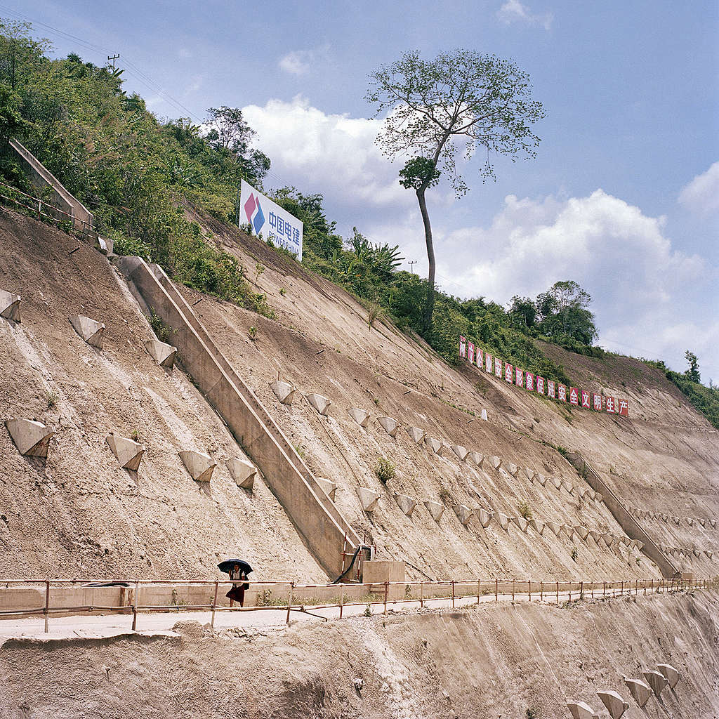 A villager crosses the concrete pavement at Nam Ou River Dam 3 site in Luang Prabang Province on 9 June 2019 in Laos. The Nam Ou dam project is a cascade of 7 dams that spans over 350 kilometres of the Nam Ou River in Laos, an important tributary of the Mekong River. The Chinese funded project is being built over 10 years, with 3 dams currently in operation and the remaining being built. A total estimate of 89 villages will be displaced. The country’s environmental and social landscape will be altered in irreversible and disproportionate ways. Ore Huiying