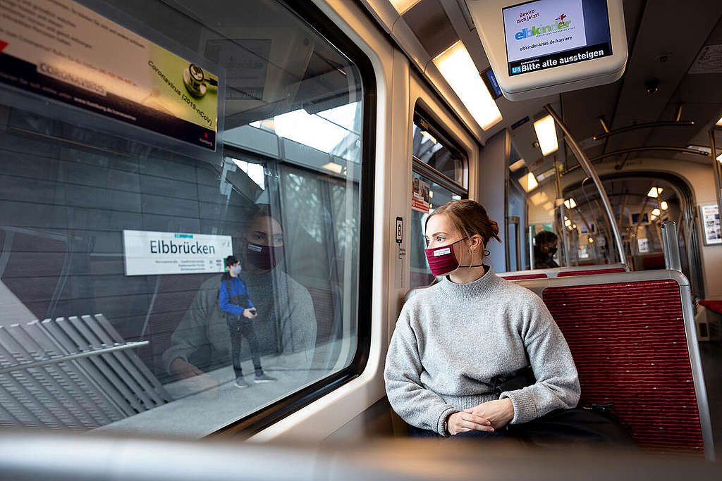 A woman wears a mouth and nose protection mask in public transport. 